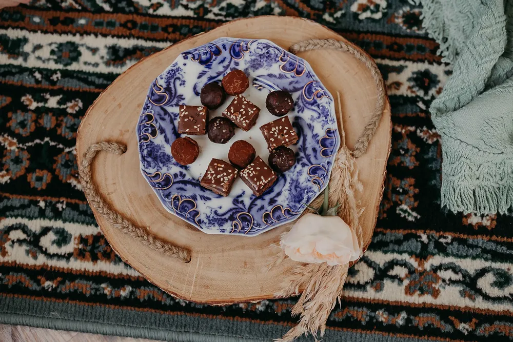 Halva dessert pieces on a blue and white patterned ceramic plate, presented on a wooden surface.