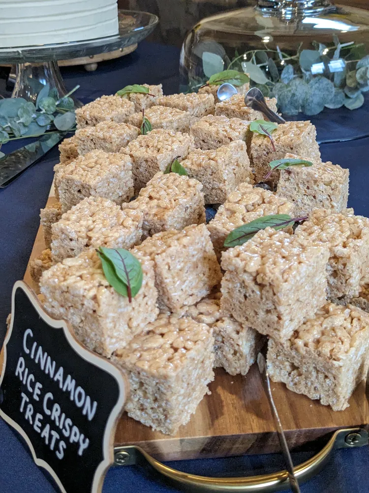 Cinnamon rice treats arranged on a wooden board, garnished with greenery. A delicious and festive dessert.